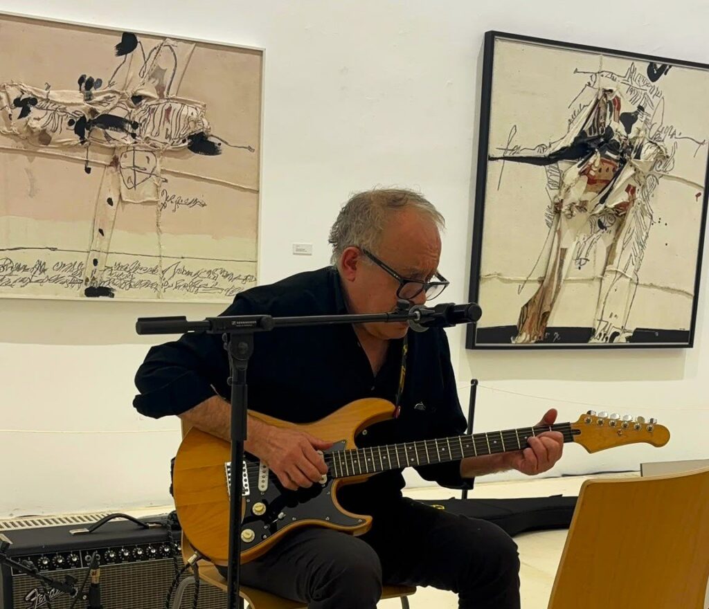 Julián Hernández toca la guitarra al final de la charla del ciclo Malos Tiempos para la Lírica