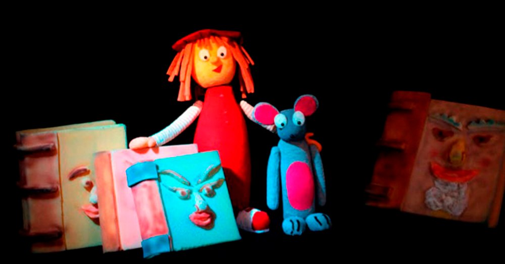 La protagonista de «La buscadora de cuentos» rodeada de libros con cara, en el espectáculo de Teatro de Carmen