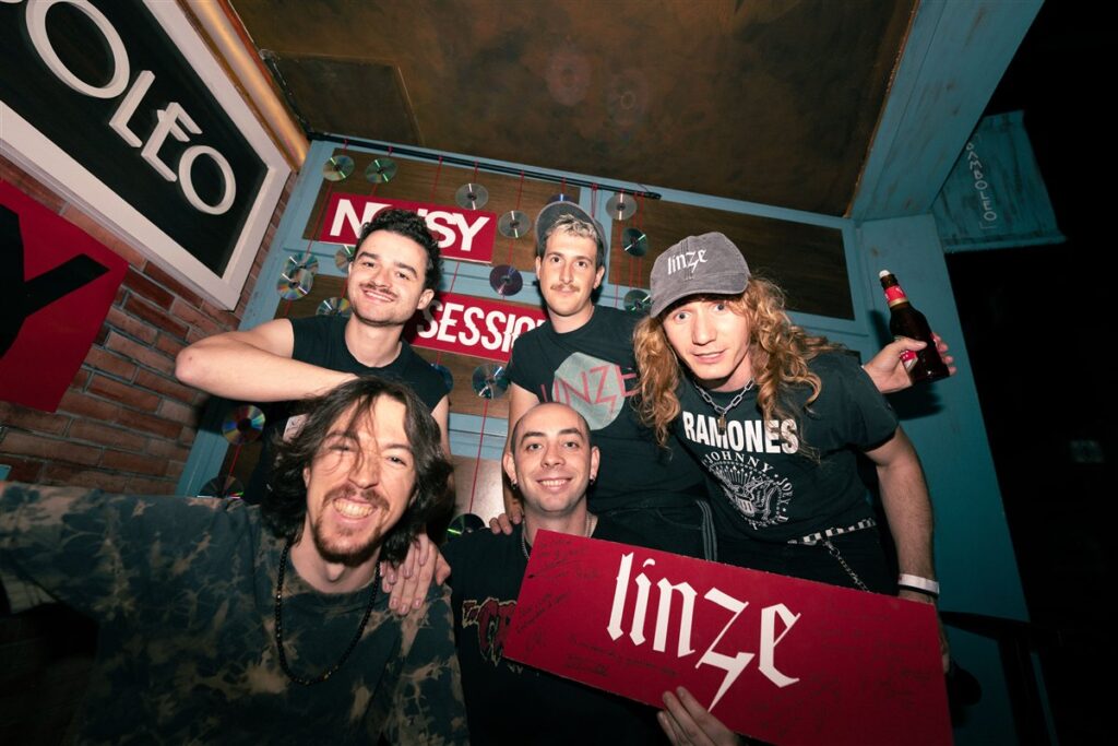 Linze, con el cartel de la banda, junto al equipo de Noisy en la Sala Bamboleo