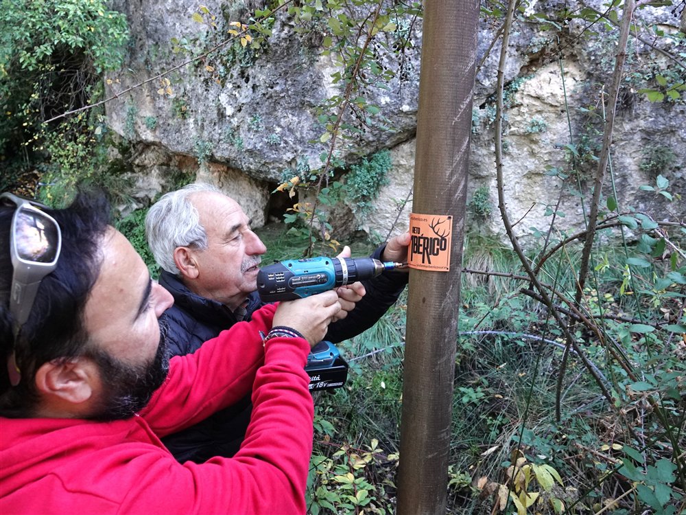 Colocación de las señales del Reto Ibérico en un poste del sendero
